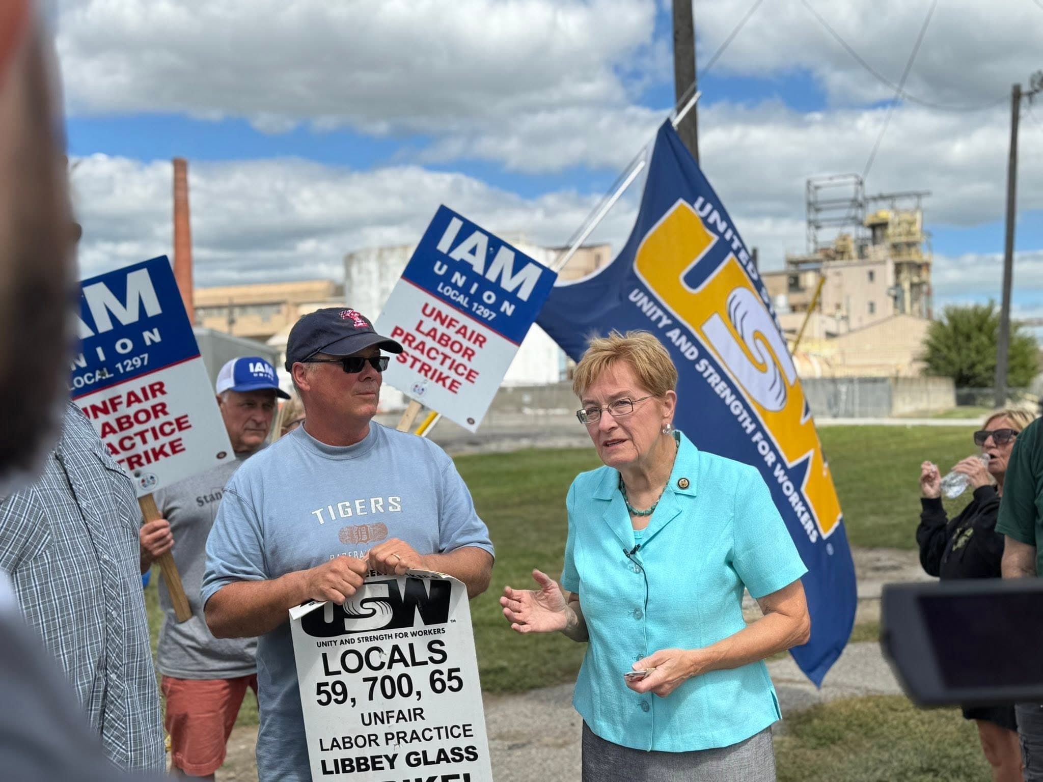 Marcy Kaptur speaking with union workers holding IAM and USW picket signs